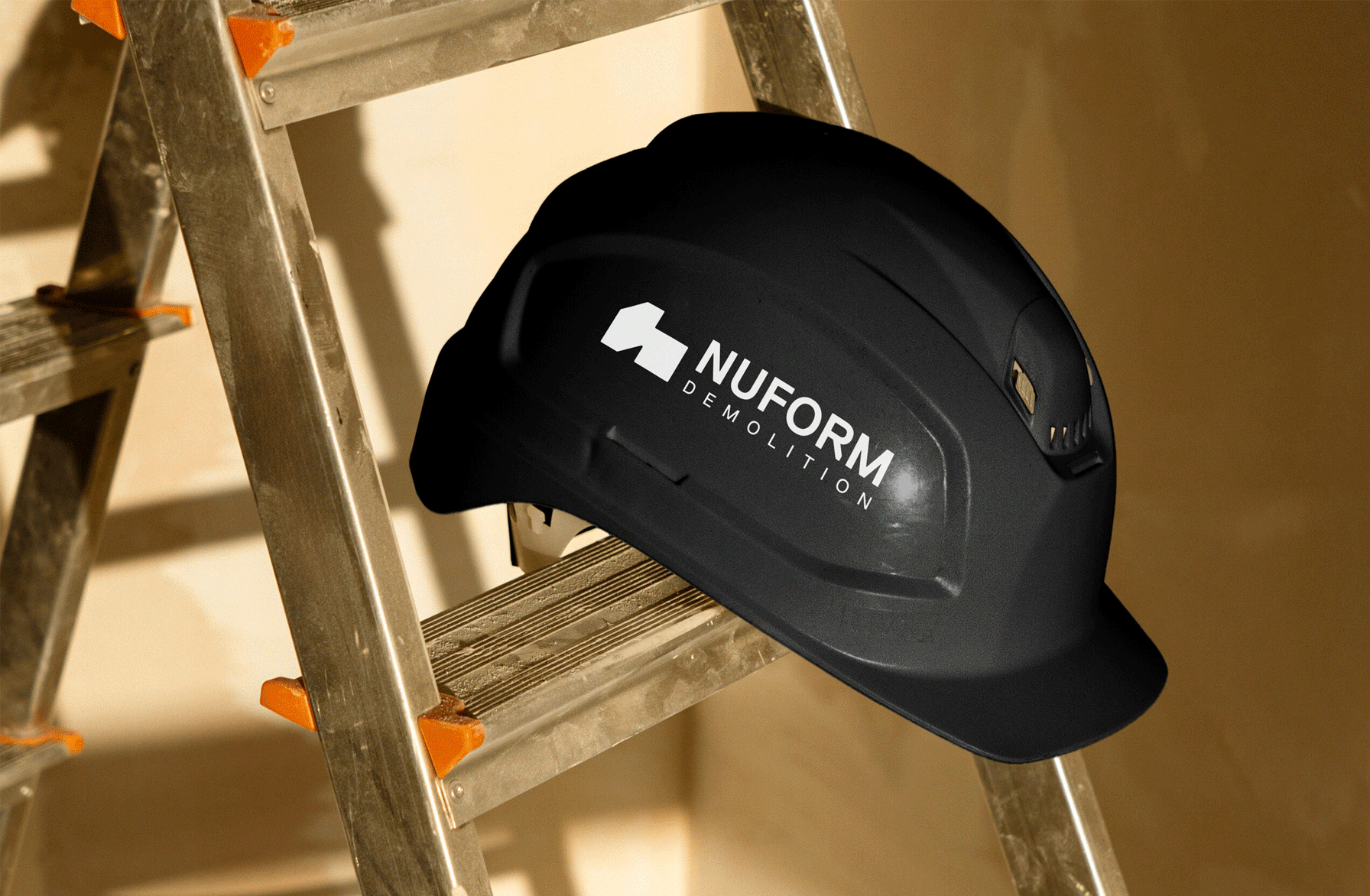 logo on black hardhat, stationery design on dark background and website design on an iphone